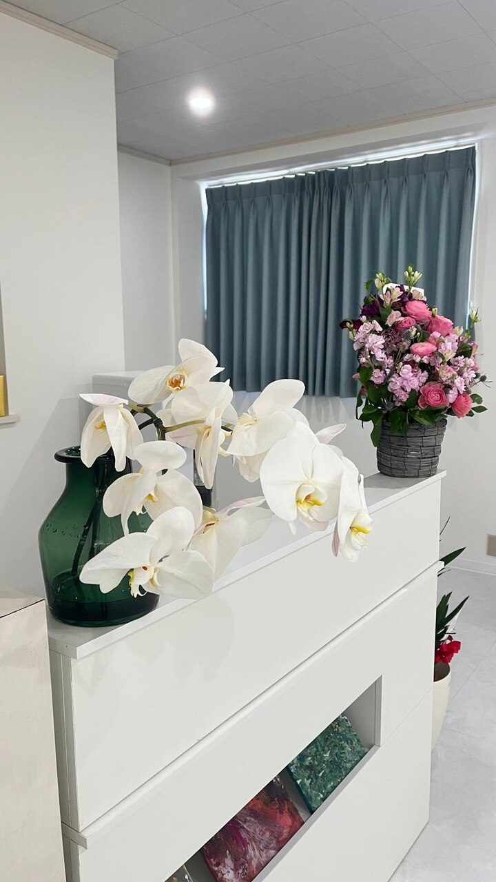 HIKKA仙台の店内の白い棚に飾った、白い胡蝶蘭とピンクの花かご