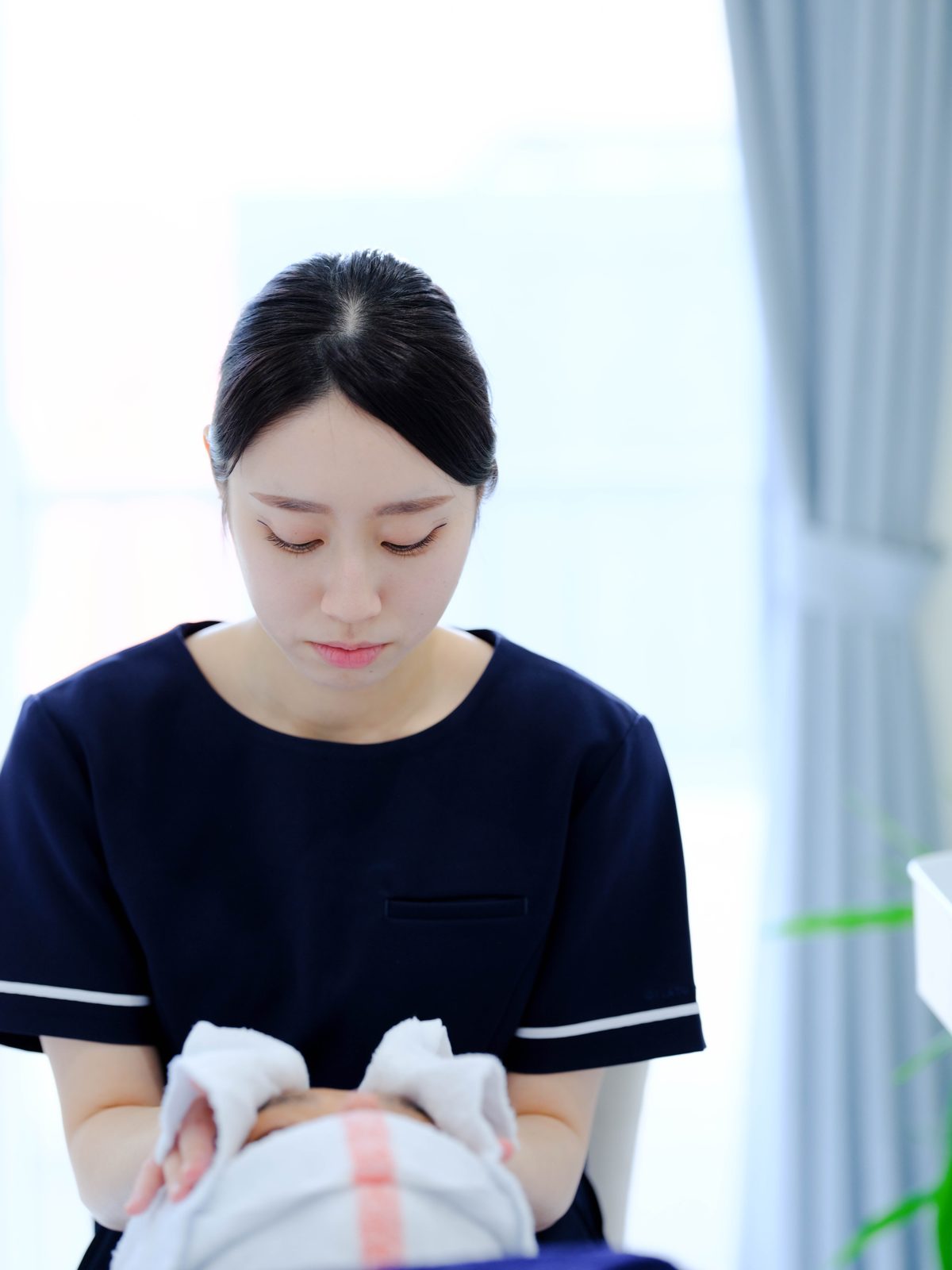 温かいタオルを両手で広げて、お顔全体を包みます。
